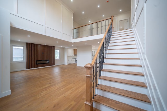396 Argyle Rd, East Meadow, NY 11554 - stairway with wood finished floors, a high ceiling, recessed lighting, and baseboards