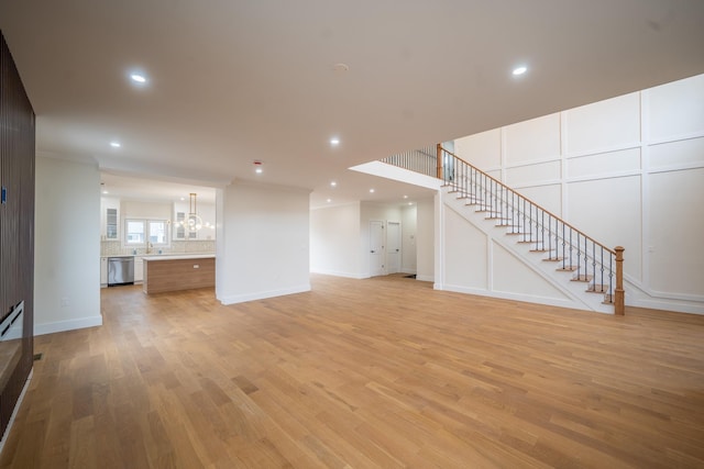 396 Argyle Rd, East Meadow, NY 11554 - unfurnished living room featuring light wood-type flooring, stairs, a chandelier, baseboards, and recessed lighting
