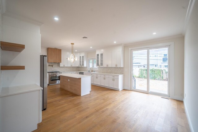 396 Argyle Rd, East Meadow, NY 11554 - kitchen with crown molding, stainless steel appliances, tasteful backsplash, a center island, and a chandelier