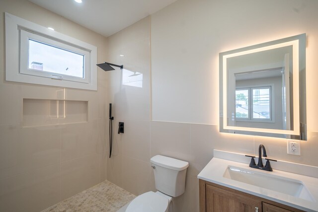 396 Argyle Rd, East Meadow, NY 11554 - full bathroom with a tile shower, vanity, toilet, and tile walls