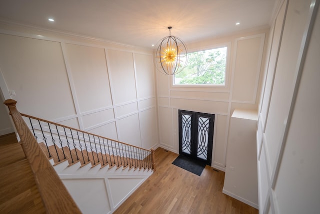 396 Argyle Rd, East Meadow, NY 11554 - foyer entrance with a decorative wall, a chandelier, stairway, wood finished floors, and recessed lighting