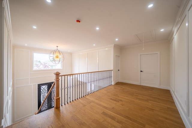 396 Argyle Rd, East Meadow, NY 11554 - hall with attic access, wood finished floors, ornamental molding, a chandelier, and an upstairs landing