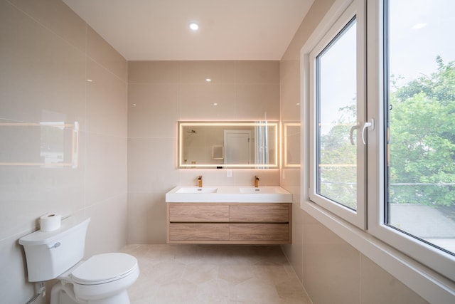 396 Argyle Rd, East Meadow, NY 11554 - bathroom with tile walls, plenty of natural light, toilet, double vanity, and tile patterned floors