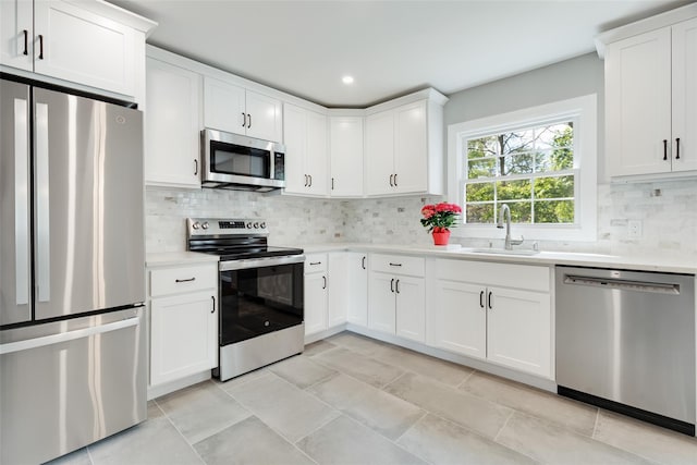 5 Helen Dr, Wappingers Falls, NY 12590 - kitchen with stainless steel appliances, a sink, light countertops, decorative backsplash, and white cabinets