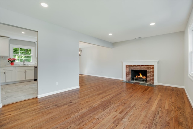 5 Helen Dr, Wappingers Falls, NY 12590 - unfurnished living room with a sink, a fireplace, recessed lighting, light wood-style flooring, and baseboards