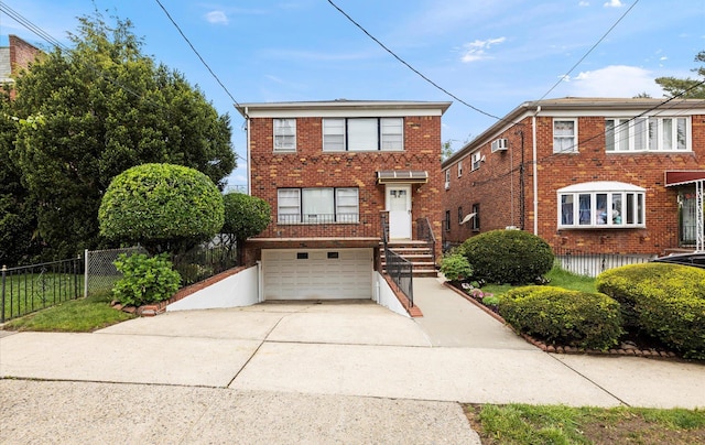 traditional-style home featuring driveway, brick siding, an attached garage, and fence
