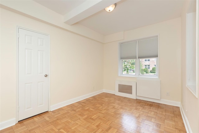 empty room with beam ceiling and baseboards