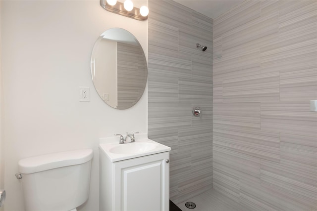 full bathroom with tiled shower, toilet, and vanity