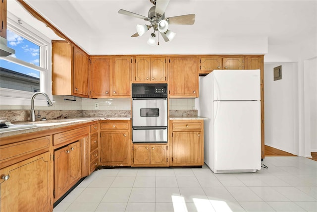 146-24 27th Ave, Flushing, NY 11354 - kitchen featuring freestanding refrigerator, stainless steel oven, a warming drawer, a sink, and brown cabinets