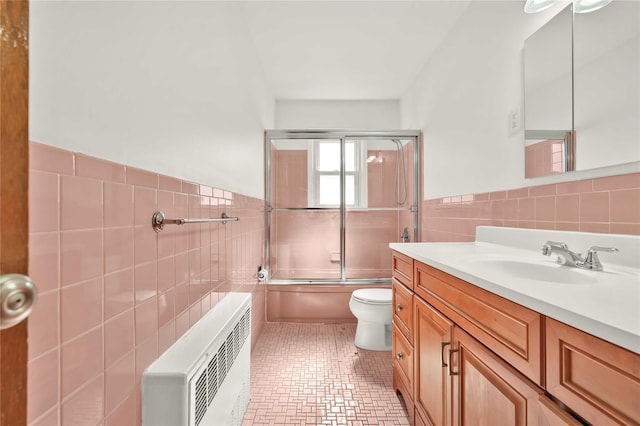 146-24 27th Ave, Flushing, NY 11354 - bathroom featuring tile walls, heating unit, vanity, wainscoting, and toilet