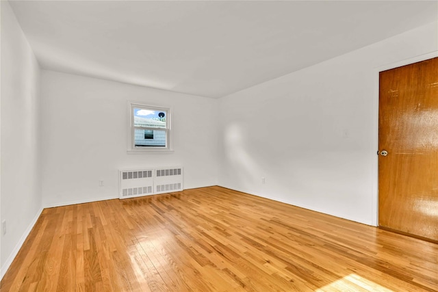146-24 27th Ave, Flushing, NY 11354 - spare room with radiator heating unit, light wood-style flooring, and baseboards