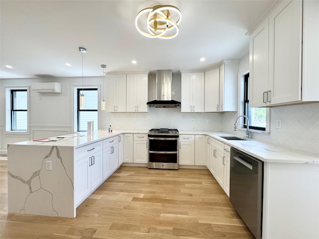 8831 69th Ave, Forest Hills, NY 11375 - kitchen featuring appliances with stainless steel finishes, wall chimney range hood, a wall unit AC, a peninsula, and a sink
