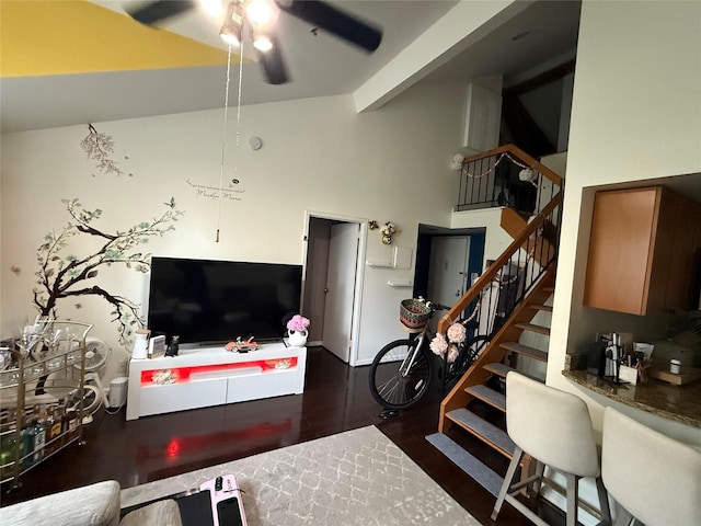 living room with stairway, ceiling fan, high vaulted ceiling, beam ceiling, and wood finished floors