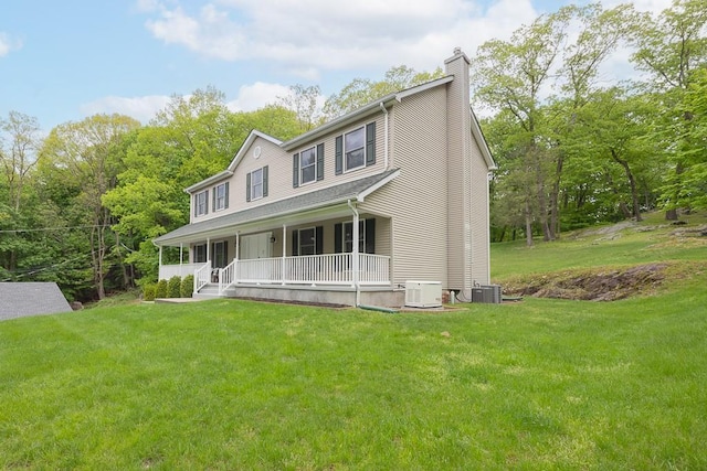 view of front of home with a porch, a chimney, central air condition unit, and a front yard