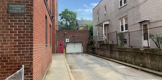 745 E 231st St Unit 1F, Bronx, NY 10466 - view of side of property featuring driveway, brick siding, an attached garage, and fence