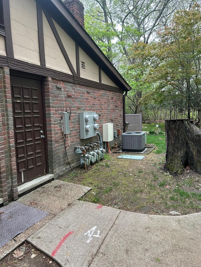 118 Skyline Dr, Coram, NY 11727 - view of property exterior with a chimney, central AC unit, and brick siding