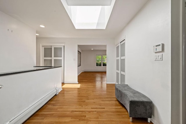 8 Beaumont Dr, New City, NY 10956 - corridor with a baseboard heating unit, a skylight, light wood-style floors, recessed lighting, and baseboards