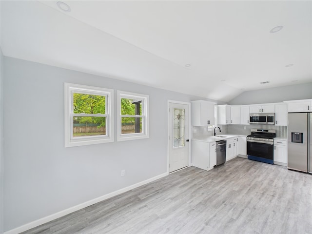 495 Easton St, Ronkonkoma, NY 11779 - kitchen featuring stainless steel appliances, vaulted ceiling, a sink, light countertops, and decorative backsplash