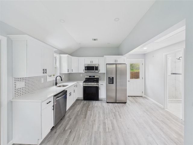 495 Easton St, Ronkonkoma, NY 11779 - kitchen featuring appliances with stainless steel finishes, a sink, backsplash, light countertops, and lofted ceiling