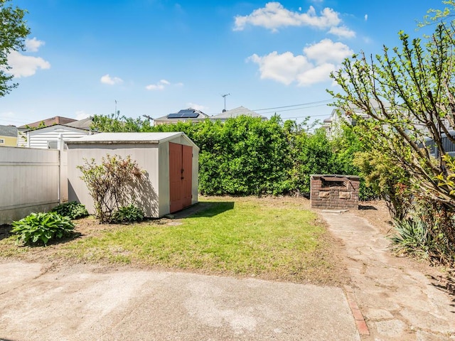 view of yard featuring an outdoor structure, a storage shed, and fence
