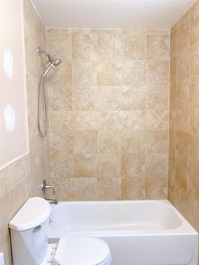 bathroom with toilet, tile walls, and shower / tub combination