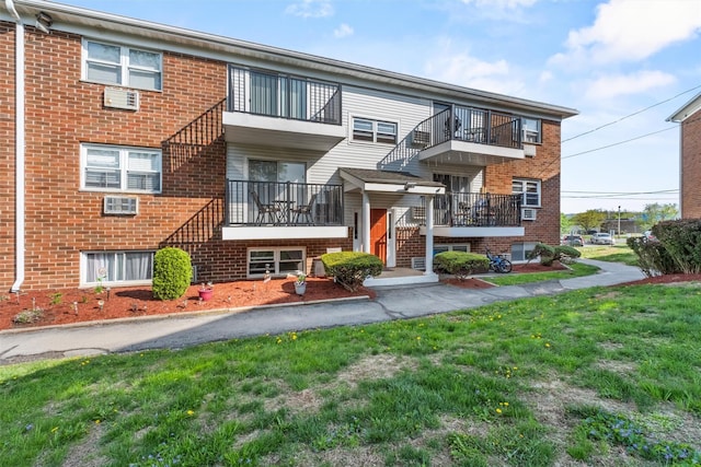 townhome / multi-family property featuring brick siding and a front lawn