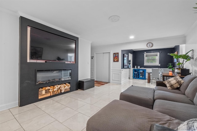 living room featuring ornamental molding, a glass covered fireplace, an office area, light tile patterned floors, and recessed lighting