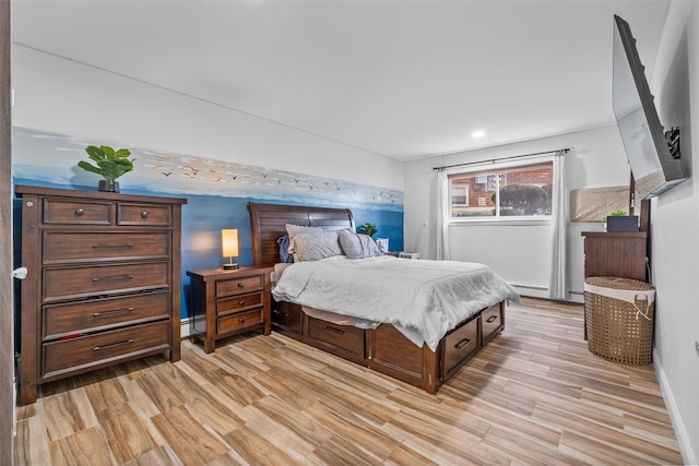 bedroom with light wood-style floors and a baseboard radiator