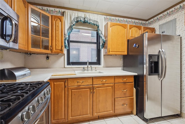 139-15 83rd Ave Unit 409, Briarwood, NY 11435 - kitchen featuring stainless steel appliances, a sink, brown cabinets, glass insert cabinets, and light countertops