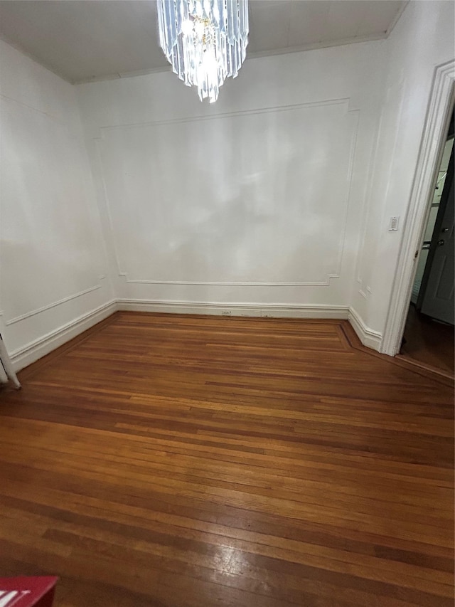 unfurnished dining area with wood finished floors and a chandelier