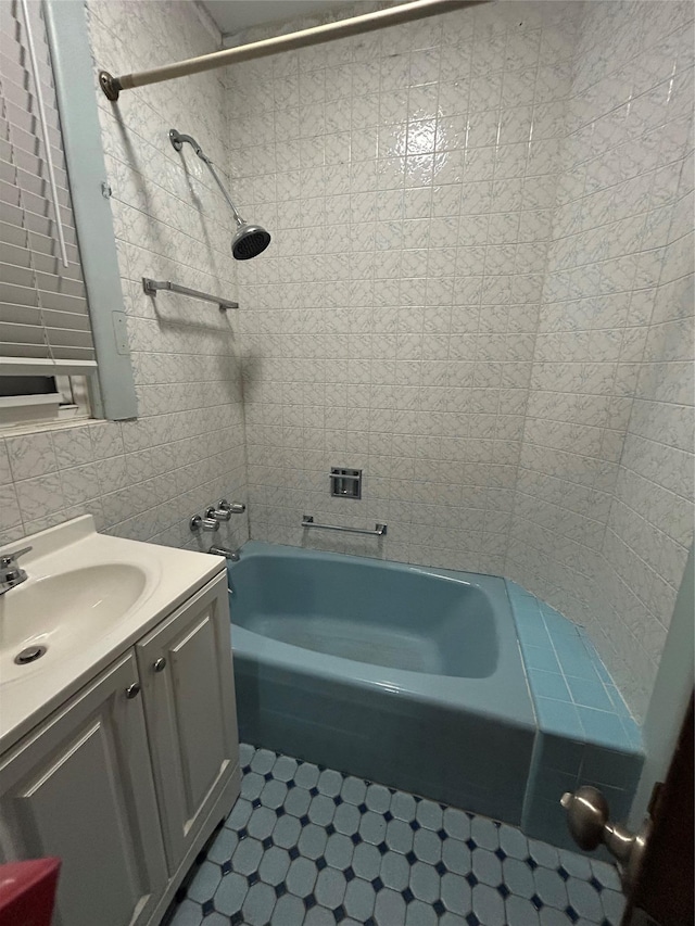 bathroom with vanity, shower / washtub combination, tile walls, and tile patterned floors