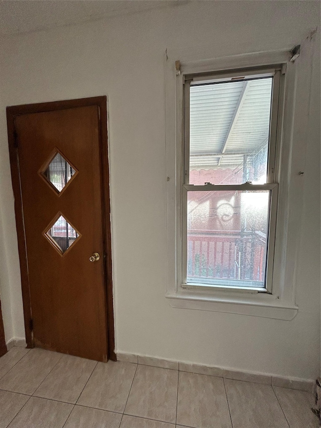 foyer featuring light tile patterned floors and baseboards