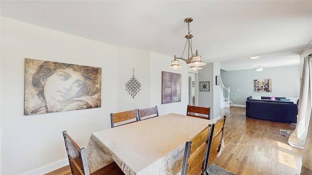 1079 Candlewood Rd, Brentwood, NY 11717 - dining area featuring hardwood / wood-style floors, stairway, and baseboards