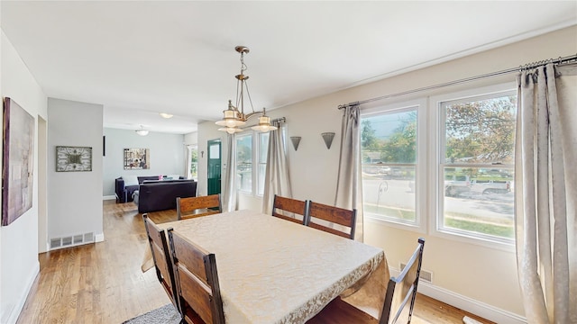 1079 Candlewood Rd, Brentwood, NY 11717 - dining space with light wood-style flooring, healthy amount of natural light, and baseboards