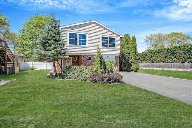 view of front facade with driveway, brick siding, and a garage