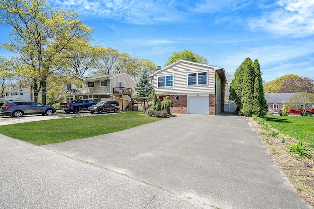 view of front of property featuring a garage, driveway, brick siding, a front yard, and a residential view
