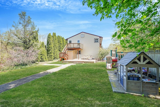 view of green lawn featuring a deck and stairway