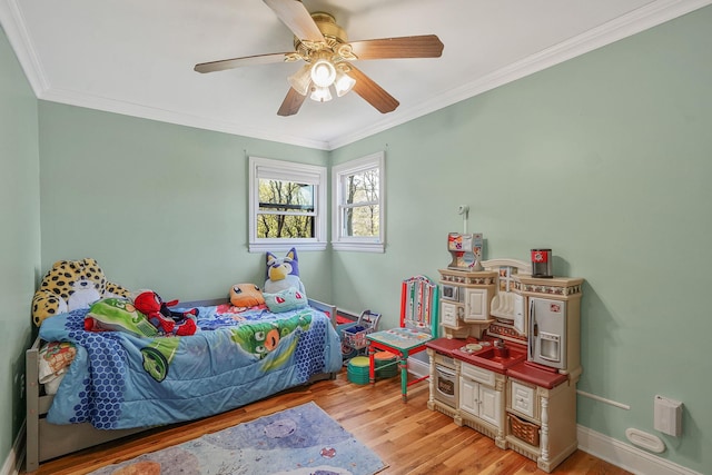 bedroom with light wood-type flooring, ornamental molding, ceiling fan, and baseboards