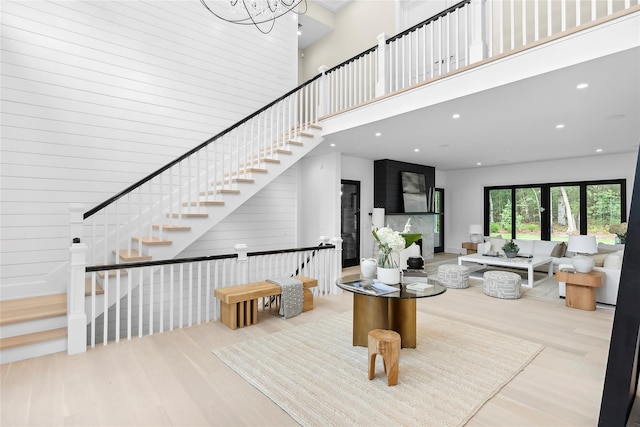 stairs featuring a high ceiling, wood finished floors, and recessed lighting