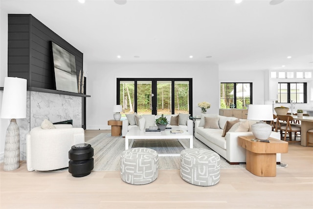 living room with recessed lighting, wood finished floors, and a high end fireplace