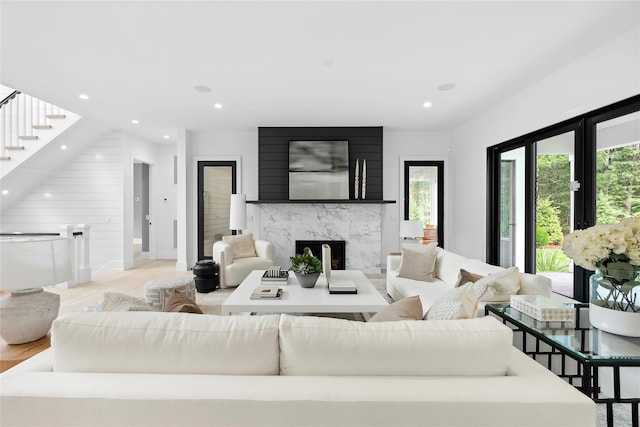 living room with a fireplace, light wood-style flooring, recessed lighting, stairs, and baseboards