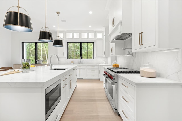 kitchen featuring stainless steel appliances, a sink, white cabinetry, healthy amount of natural light, and recessed lighting