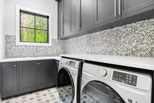 clothes washing area featuring washing machine and clothes dryer and cabinet space