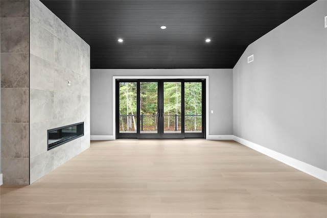 unfurnished living room featuring light wood-style flooring, baseboards, a tile fireplace, wood ceiling, and recessed lighting
