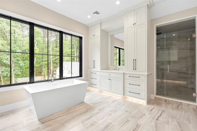 full bath with a shower stall, healthy amount of natural light, vanity, a freestanding bath, and recessed lighting