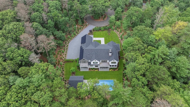 aerial view of property and surrounding area featuring a heavily wooded area