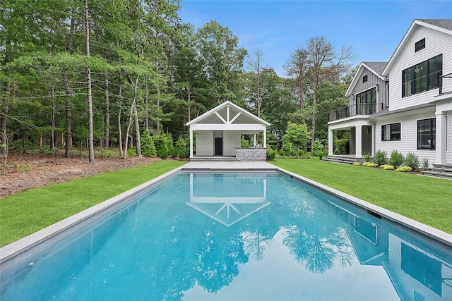swimming pool featuring a lawn and an outdoor structure