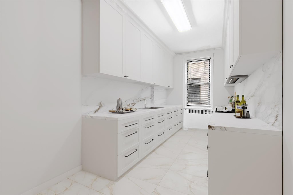 43-08 41st St Unit 5D, Sunnyside, NY 11357 - bar area featuring light marble finish floors, a sink, and radiator