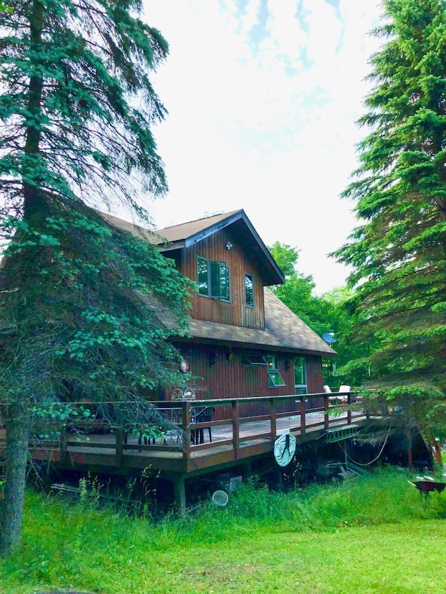 back of house with a wooden deck and a lawn