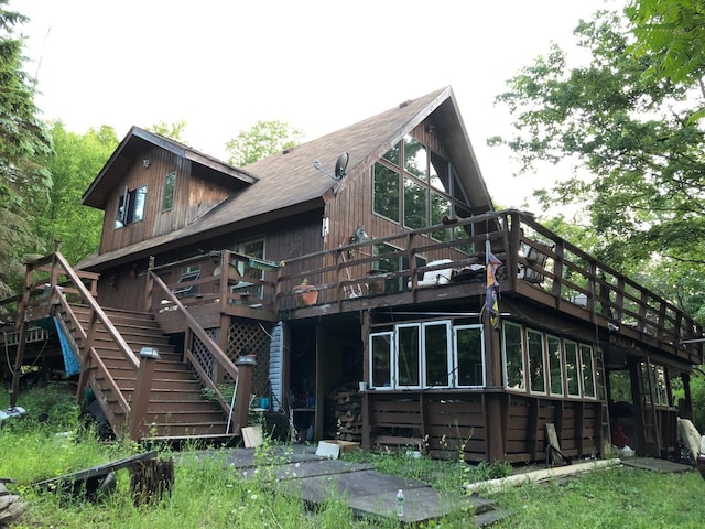 rear view of house featuring stairs and a wooden deck